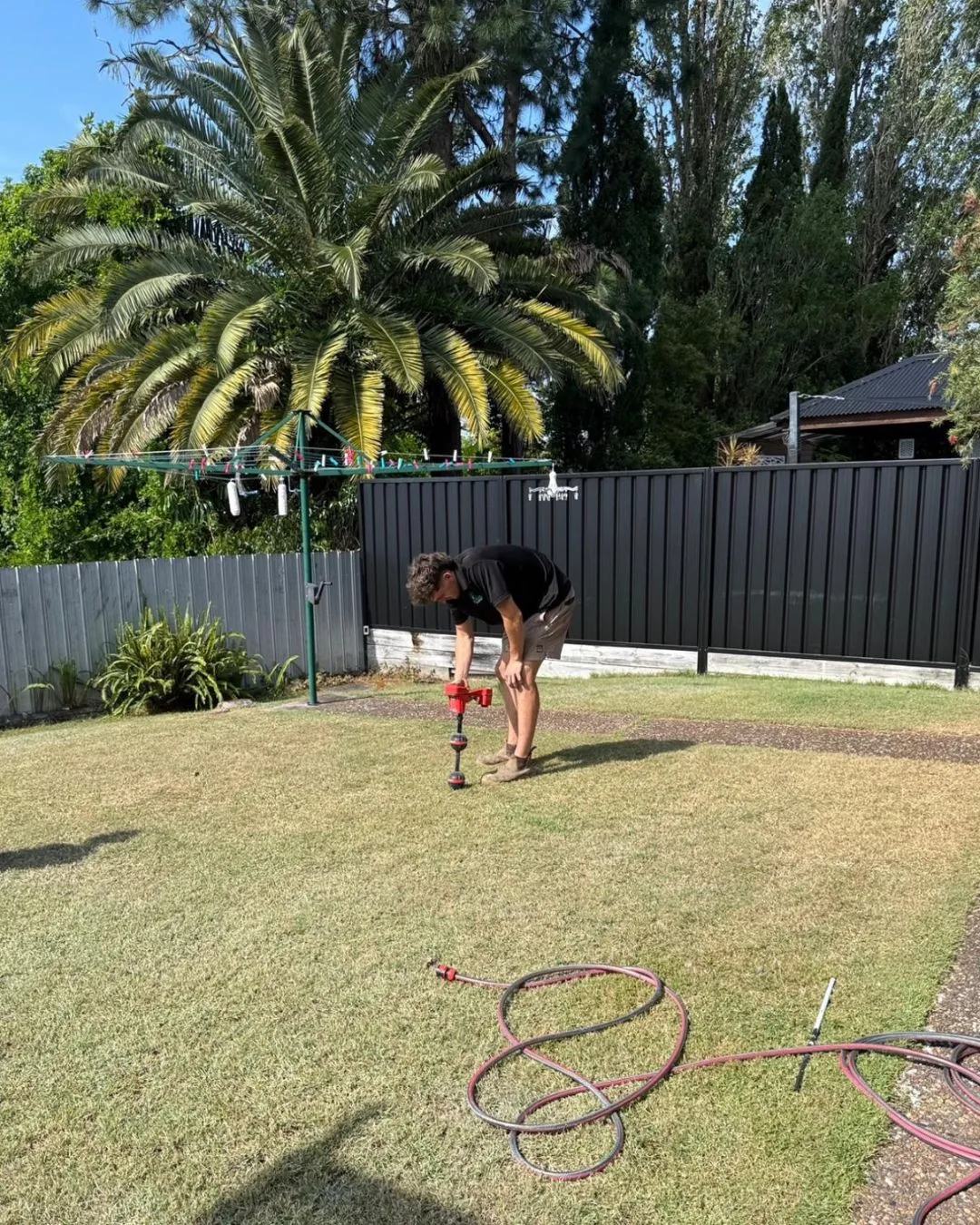 Rae.co plumber running leak detection equipment in a backyard
